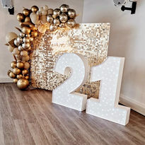 21st birthday signage with bright gold balloons