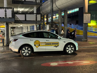 White Dan's Taxis cab parked outside an airport