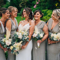 Bride and bridesmaids holding cream and pink flowers