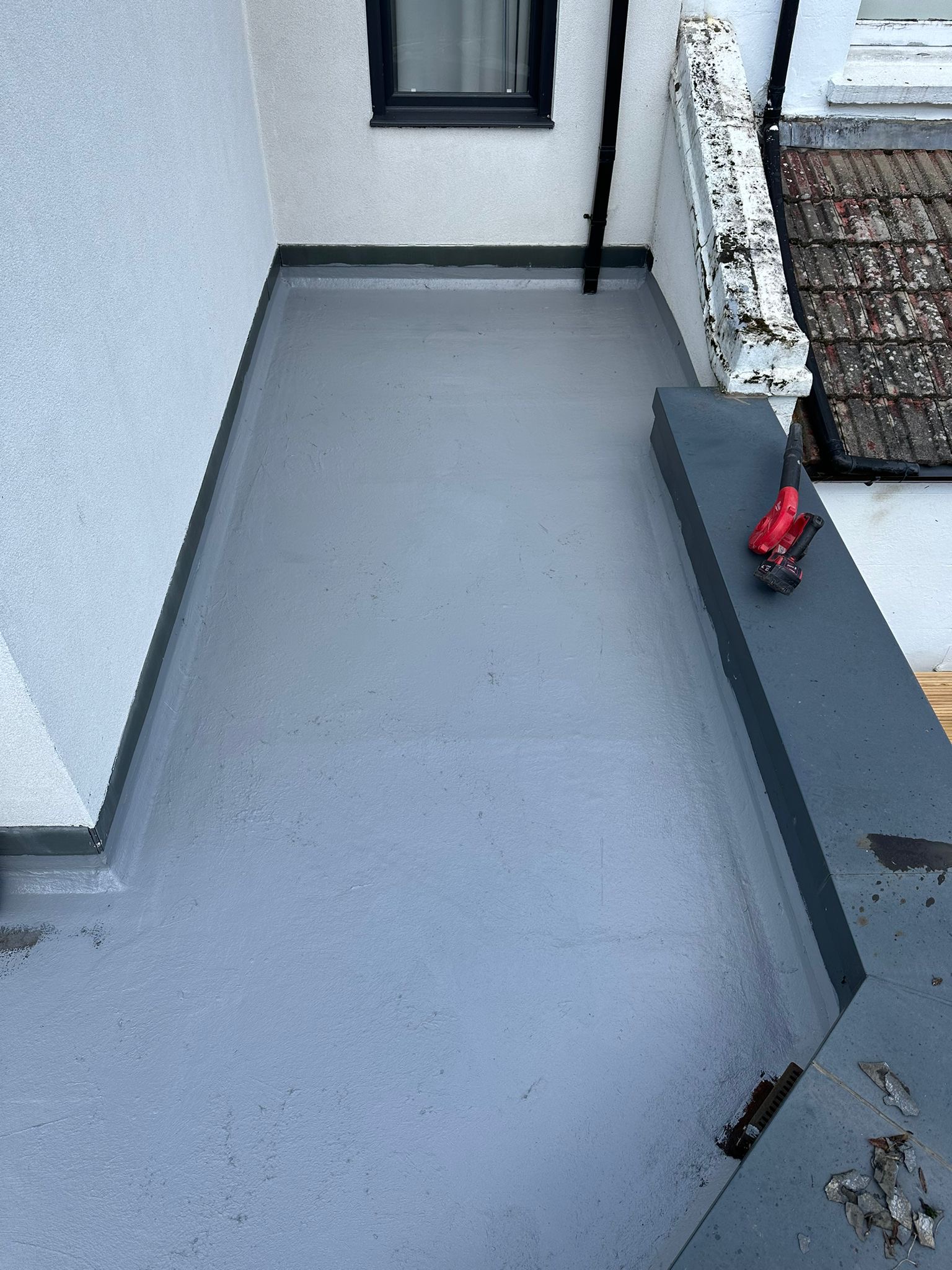 wh-roofing-grey-flat-roof-installation-beside-exterior-wall