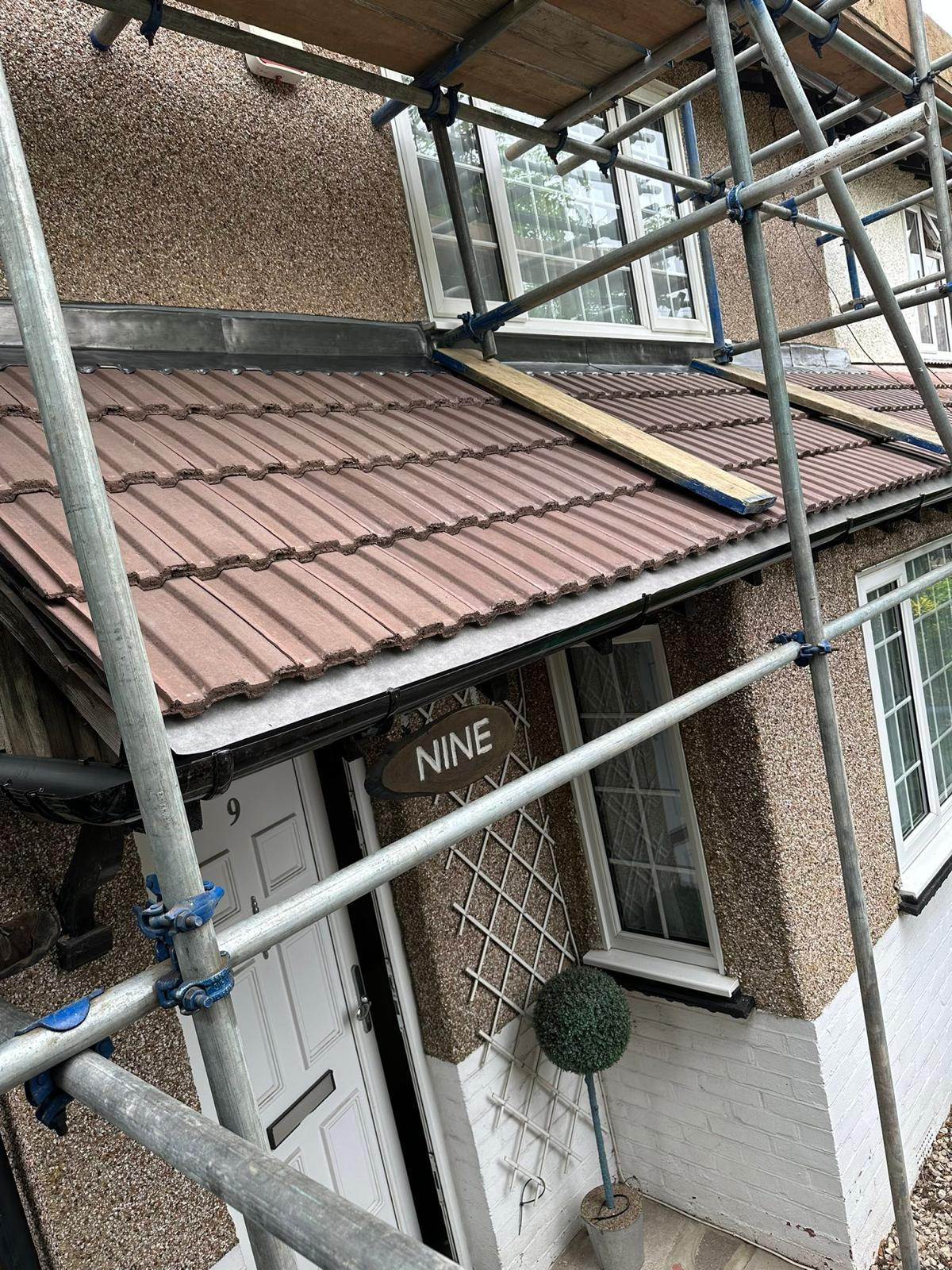 Porch roof tiling and guttering with scaffold access.