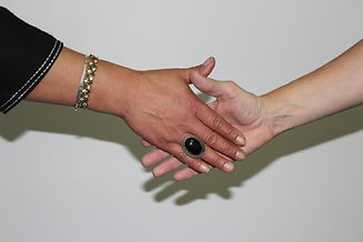 very good shot of two women reaching towards one another to shake hands.JPG