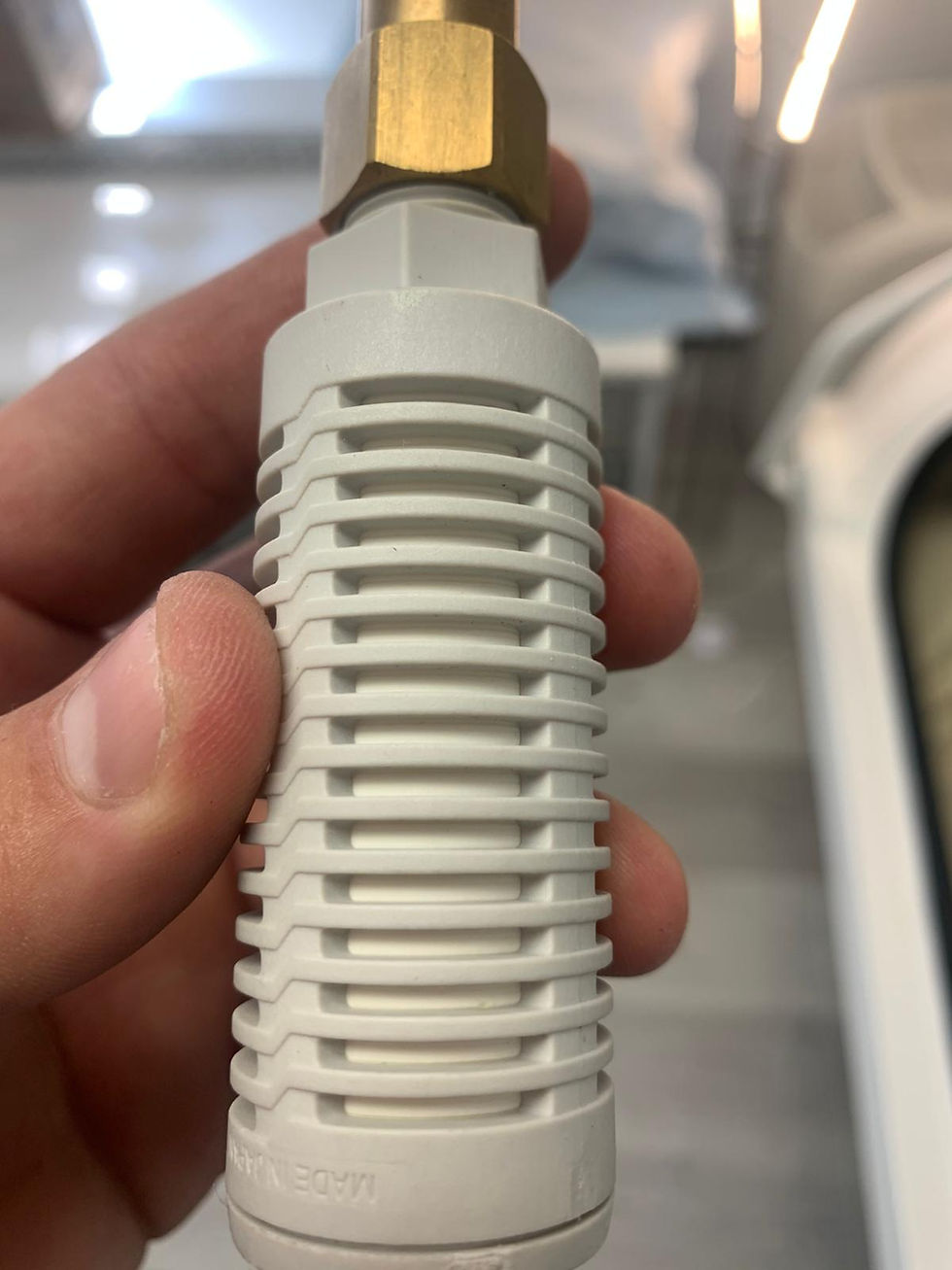 Thumbnail: Close-up shot of a hand holding a white and gold fitting.
