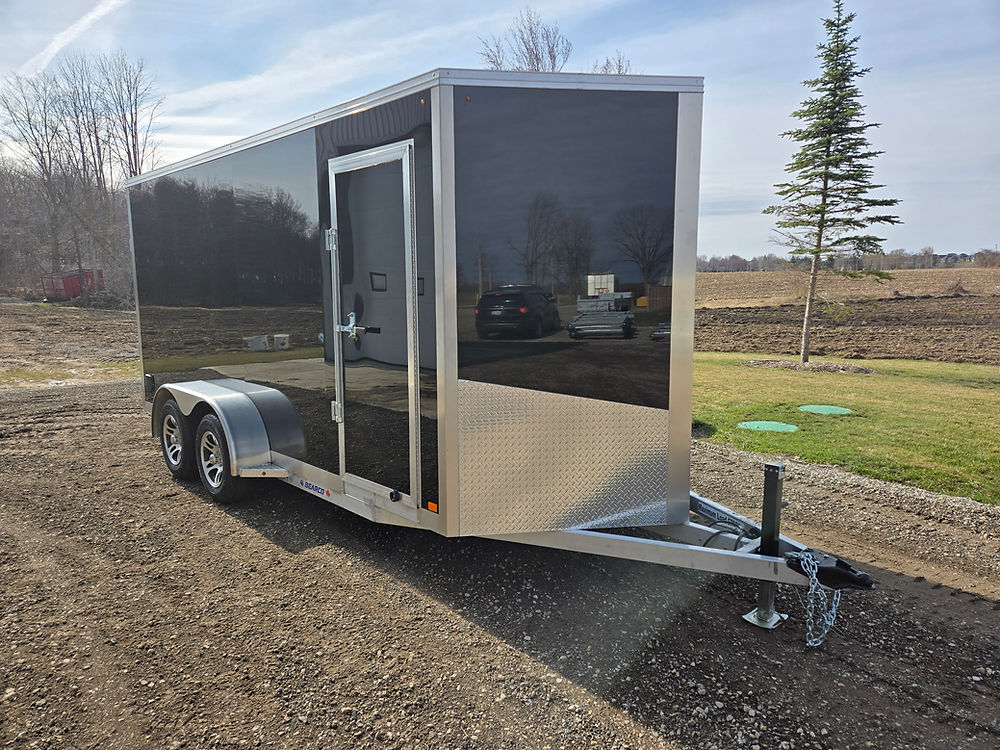 Black enclosed aluminum trailer parked outdoor.