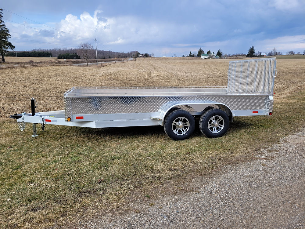 Tandem axle aluminum utility trailer on gravel path