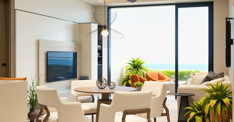 Rendering of an apartment living and dining area with a sofa, dining table and large sliding glass doors.