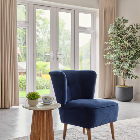 Living room with garden view and dark blue armchair with side table