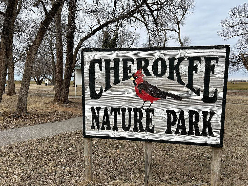 The sign at Cherokee Nature Park indicates the name of the park and shows a painting of a male red cardinal.