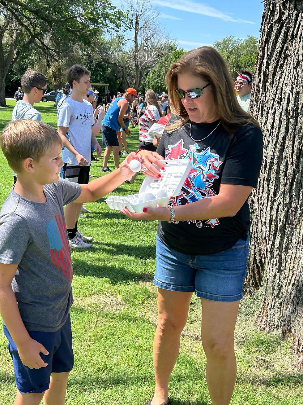 A young boy takes an egg from a woman for a game during the annual Fourth of July festival in Cherokee, Oklahoma.