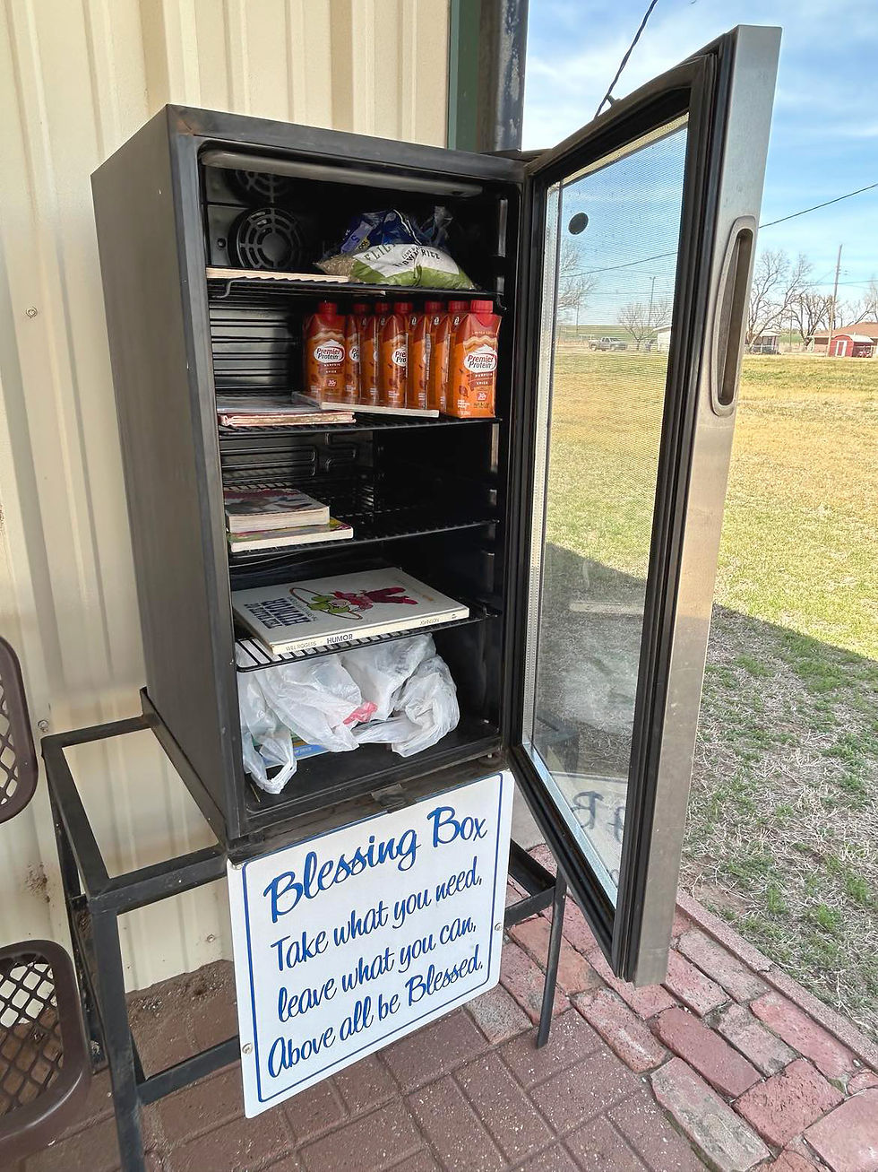 The Blessing Box at Aline Senior Center is a small refrigerator that sits outdoors and contains children's books and snacks for people to enjoy. Visitors can leave gifts to bless others as well.
