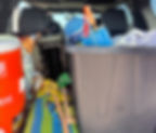 Crystal digging supplies, like shovels, a water cooler, and an umbrella, are packed in the back of a vehicle, ready for a day trip to Selenite Crystal Digging Area in Alfalfa County.