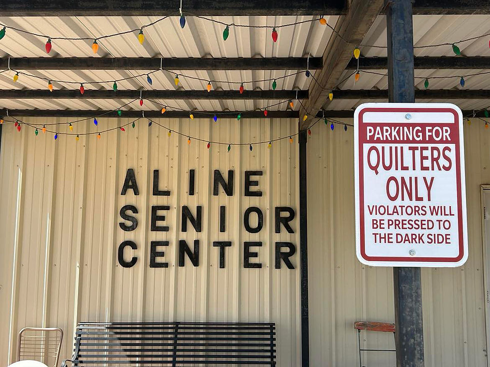 Aline Senior Center at 412 N. Main Street in Aline, Oklahoma, has public parking up front marked with a fun sign that reads, "QUILTERS ONLY. VIOLATORS WILL BE PRESSED TO THE DARK SIDE."