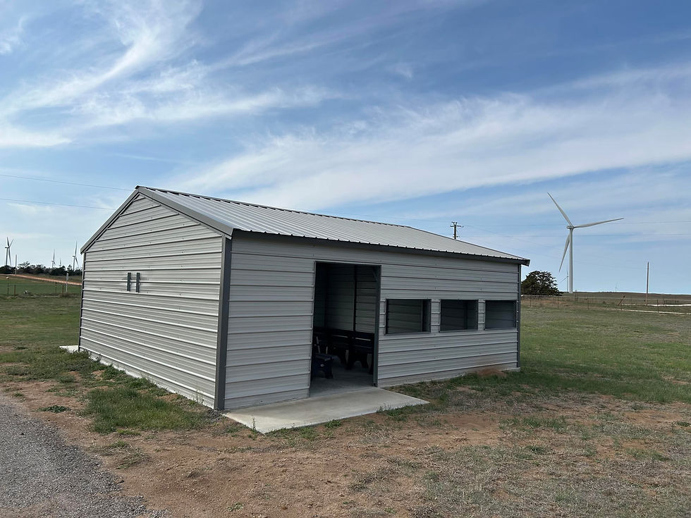 A modern community building is made of cream-colored metal and sits on the west side of the cemetery.