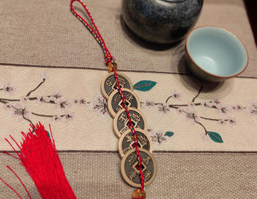 Five emperors' coins hanging behind the door: Ancient coins of the five emperors strung with red string. Old coins have been handled by many people, which can be used to enhance yang Qi (energy).