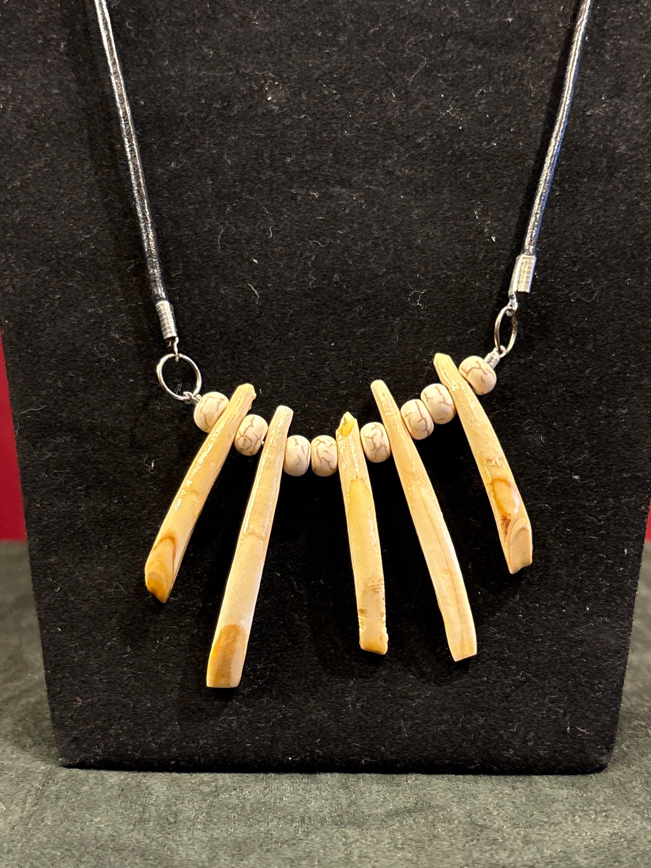 Wild boar teeth and beads on a thick leather like necklace