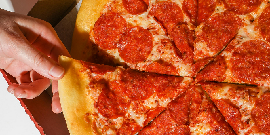 Hand grabbing a slice of pepperoni pizza