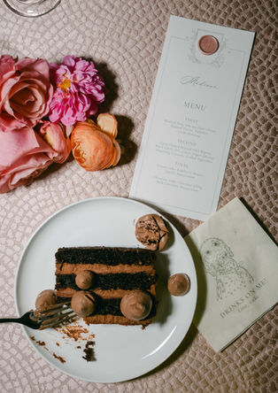 Wedding invitation suite displayed beside cocktail and vintage camera detail.