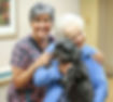 primacare senior resident with nurse hugging dog