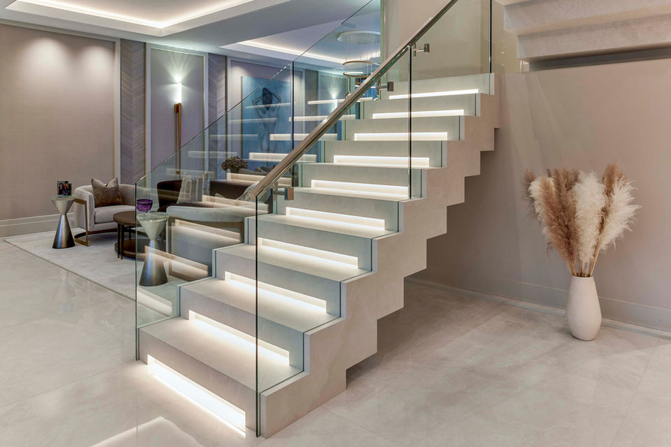 Modern floating staircase with glass railing, integrated lighting, and minimalist luxury interior design details