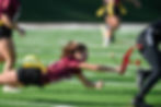 High school girls flag football player pulling a flag during a game in Northern Virginia, showing strong pursuit angle and safe breakdown