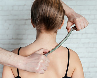 IASTM treatment, girl receiving soft tissue treatment on her neck with stainless steel too