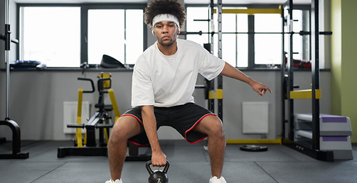 man-exercising-with-kettlebell-gym-full-shot.jpg