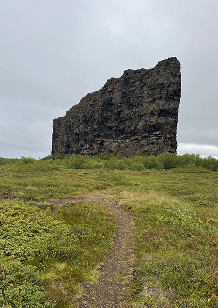 Ásbyrgi horseshoe-shaped canyon with towering basalt cliffs, lush green birch trees, and tranquil Botnstjörn lake in North Ic