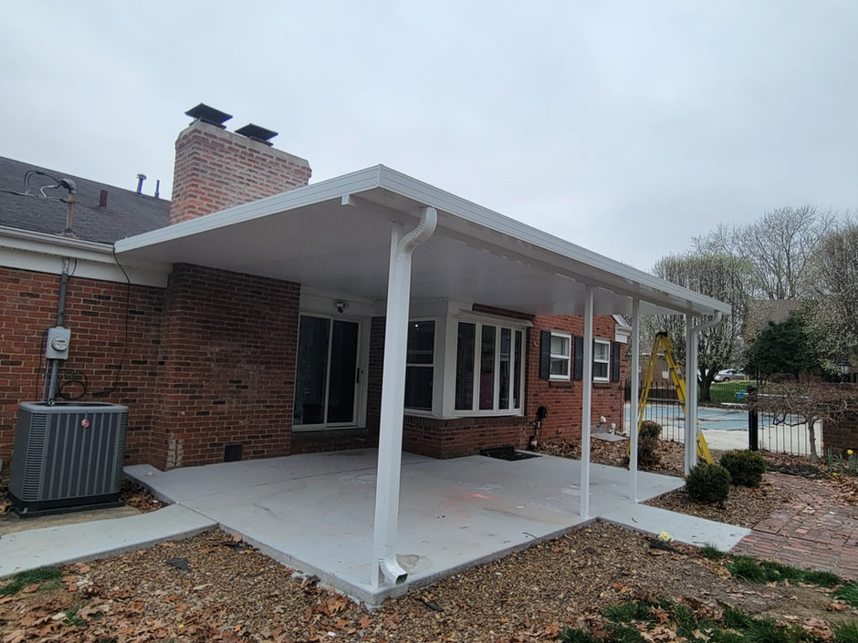 White aluminum patio cover with a gable end over a concrete patio at a red brick ranch home, built by All Weather Products.
