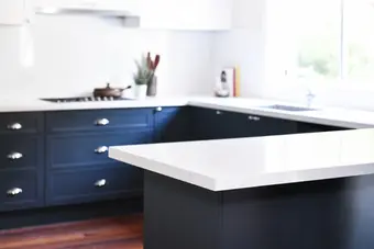 dark blue kitchen cabinets with white benchtop