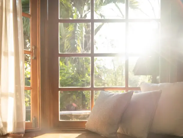 Morgensonne durch ein Fenster auf eine Bank mit Kissen