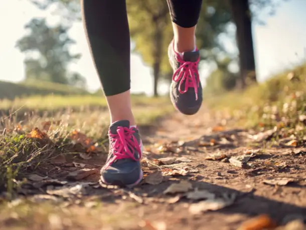 Frau joggt auf einem Feldweg