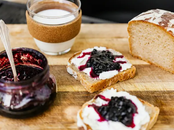 Ein Brett mit Brot und Brombeermarmelade