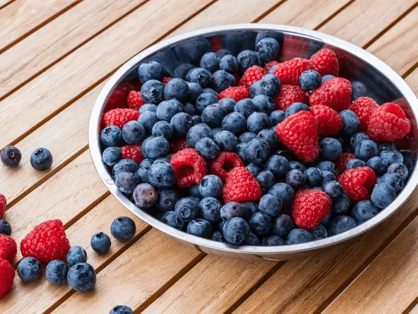 Antioxidantien in Lebensmitteln Schuessel mit frischen Heidelbeeren und Himbeeren