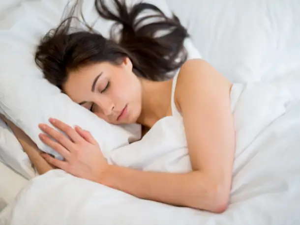 Schlafende Frau auf weißen Kissen