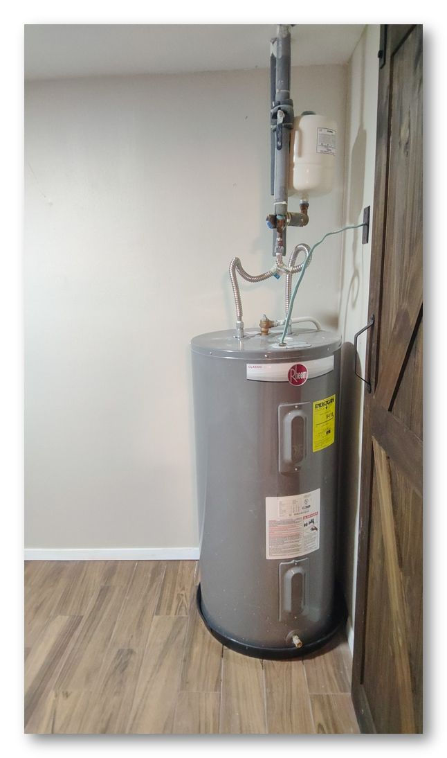 Eye-level view of a residential water heater with visible pipes, valves, and an expansion tank.