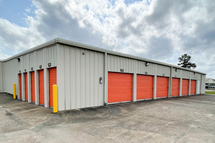 A self storage facility with orange doors at a location with security cameras and affordable storage options.