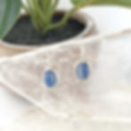 Pair of silver earrings. Simple oval design. Blue stones.