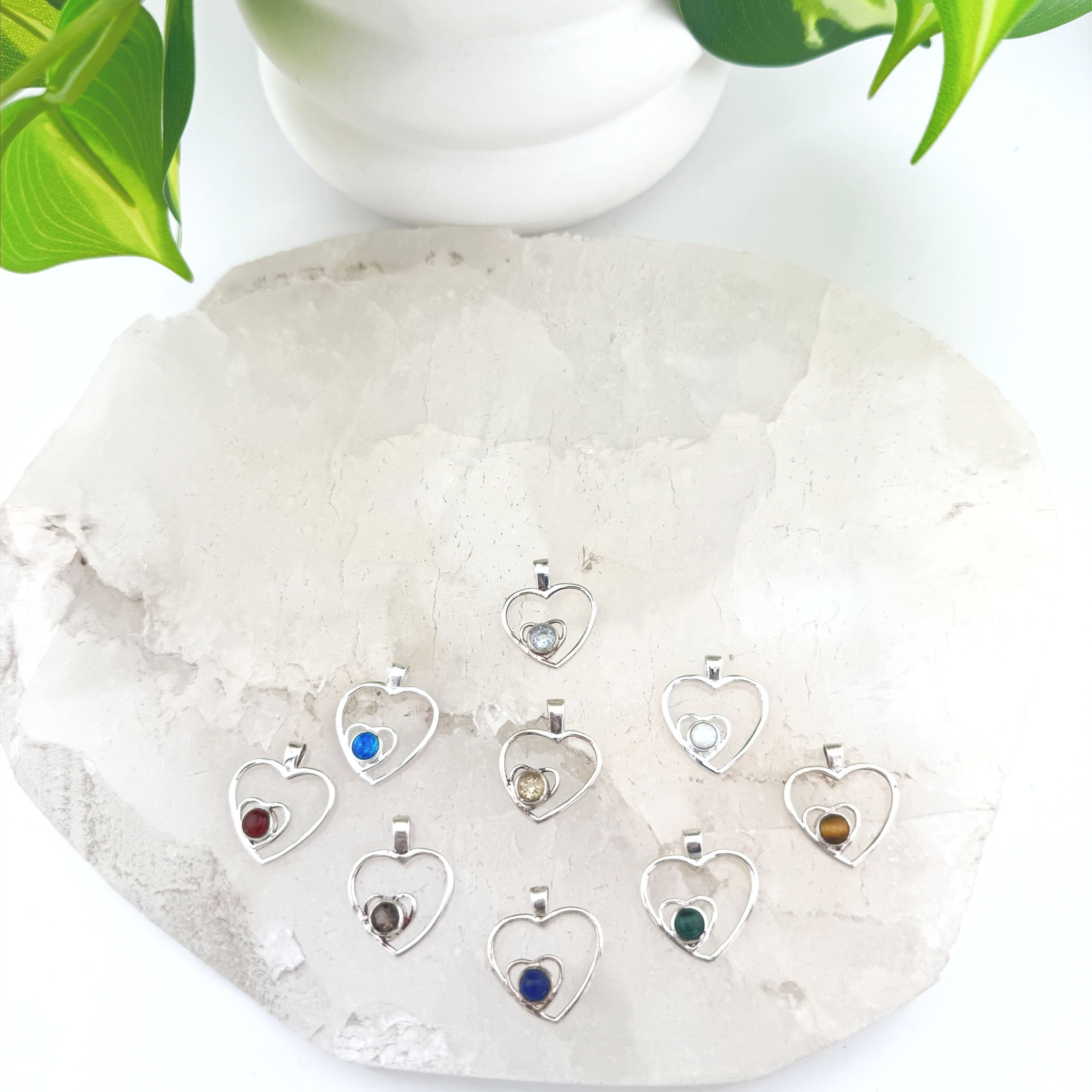 9 silver pendants. Heart shaped with smaller heart inside. Smaller heart has various stone options.