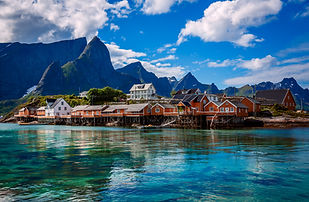 Small-group yacht exploring Lofoten fjords with mountains in background