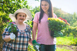 woman with down syndrome gardening with another lady