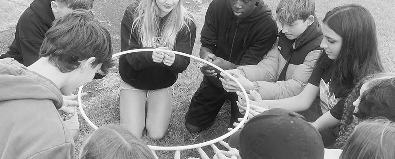 Students try to complete a team building challenge
