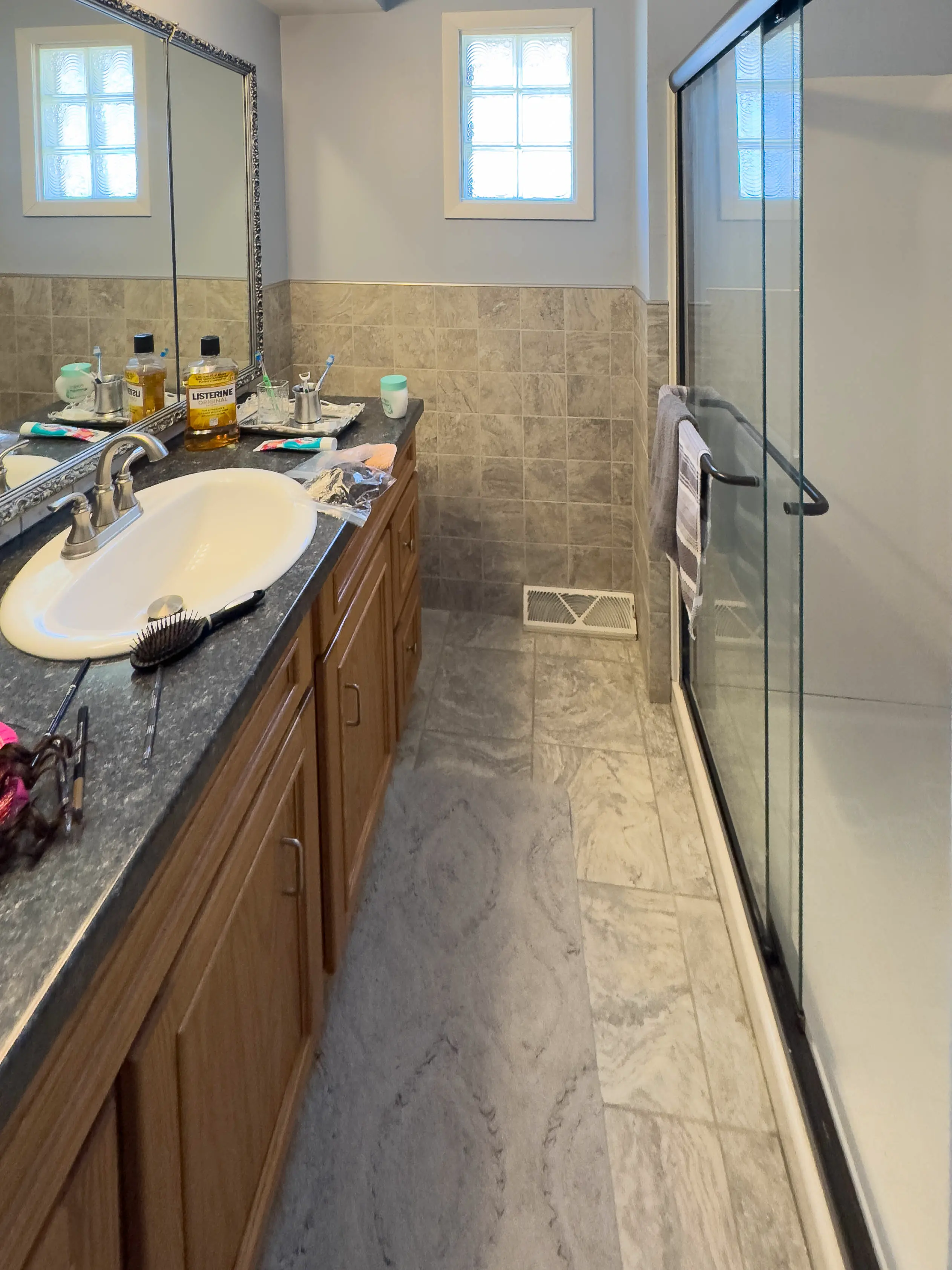 Bathroom renovation before and after – serene bathroom with dual-tone tiles, wood vanity, and soft lighting