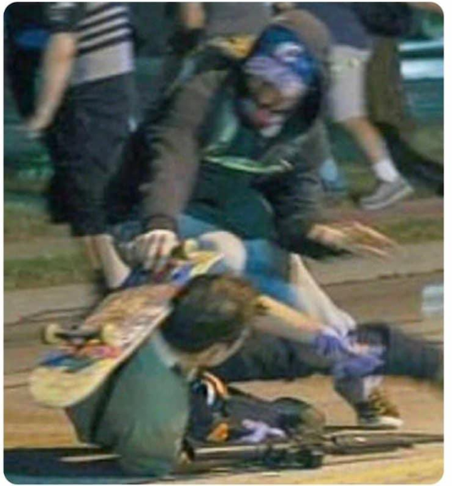 Photo of Anthony Huber standing over and hitting Kyle Rittenhouse with a skateboard during a riot in Kenosha.