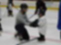 Coach on his knees helps little hockey player