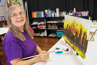 Owner and artist, Mary paints the skyline of Charlotte, N.C.