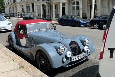 Small blue car parked on street after exterior wash