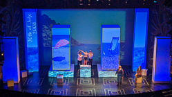 Water textures ripple across the stage as Christopher recalls his mother diving into the sea, projections layered with shifting opacities to recreate his memory of loss.