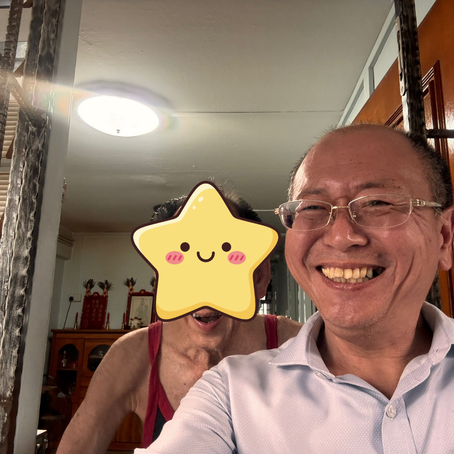 A elderly man with a bright toothy smile with his volunteer