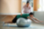 Fisioterapeuta auxiliando um paciente em um exercício de reabilitação com bola suíça em um ambiente clínico bem iluminado, focado em fisioterapia cardiorrespiratória.
