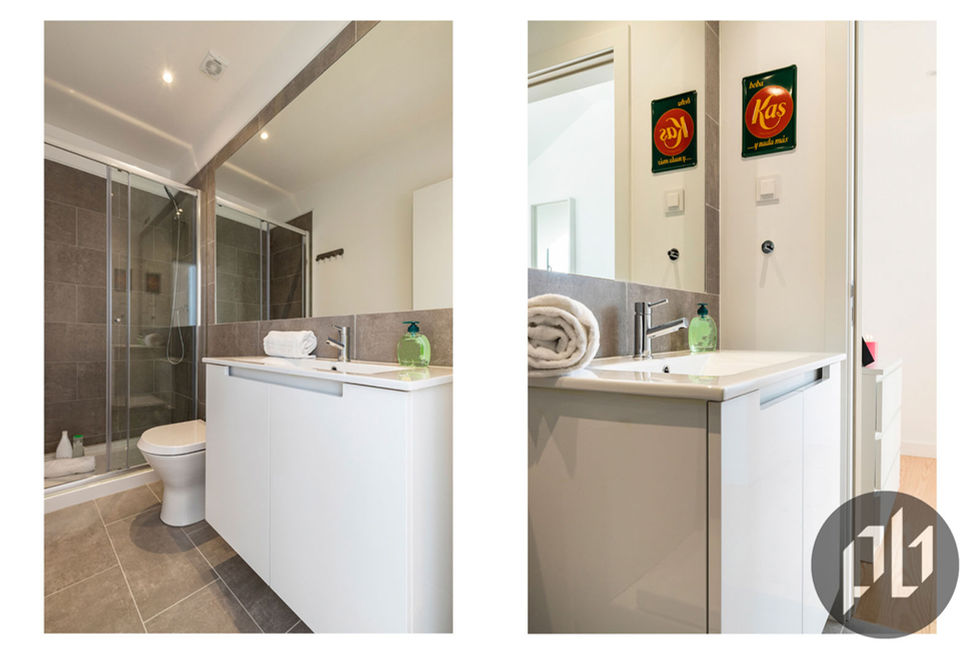 Lavatório moderno integrado em móvel branco com placas metálicas vintage "Kas" na parede lateral.